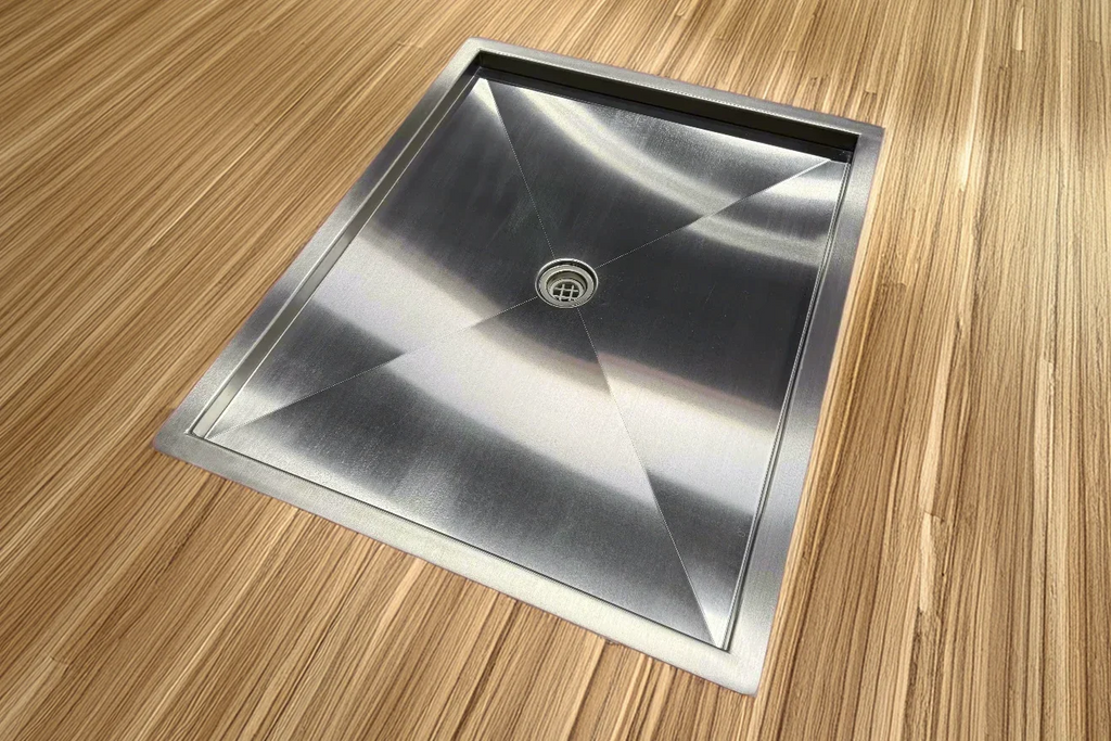 Recessed stainless steel shower pan installed in a van floor