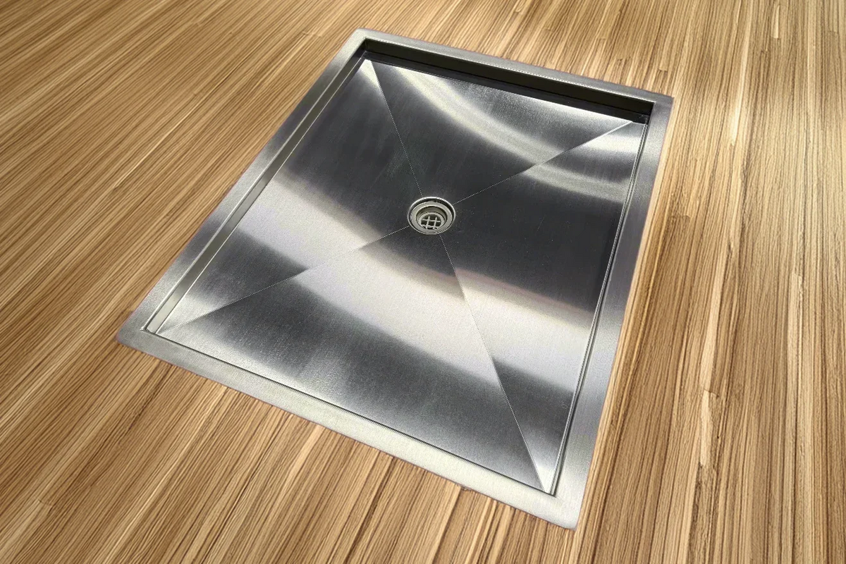 Recessed stainless steel shower pan installed in a van floor